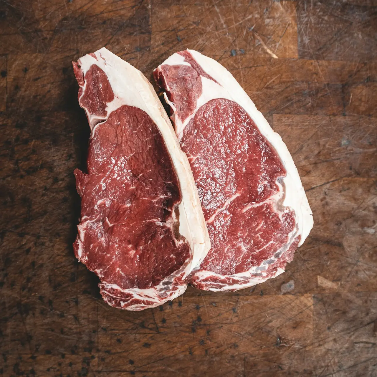 Côtes d&#39;agneaux sur une planche en bois brun. 